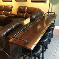 a living room filled with furniture and lots of brown leather couches on top of a wooden table