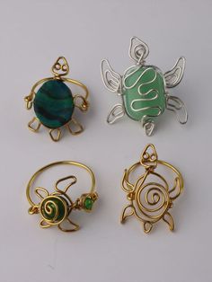 four different types of rings with designs on them, one is green and the other is gold