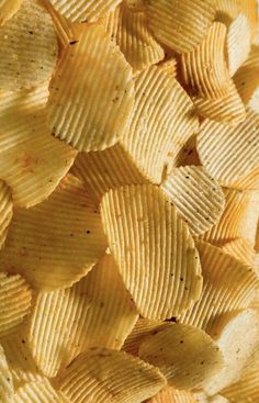 potato chips piled on top of each other in close up view to show the texture