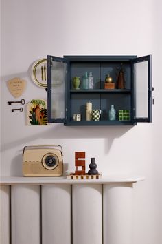 an old fashioned radio sitting on top of a table next to a wall mounted shelf