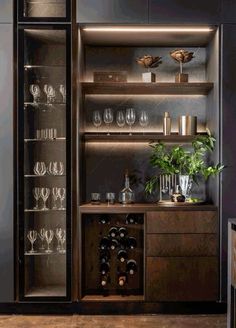 an open cabinet with wine glasses and bottles in it