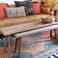 a living room with a couch, coffee table and vases on the floor in front of it