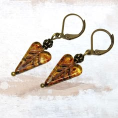 Glass heart earrings in golden brown topaz with Picasso finish are the perfect Bohemian  jewelry gift. Their rich colors evoke a sense of woodland and nature. These Czech glass earrings look great with a variety of styles, from casual to dressy. Add them to your earring collection while they last! - Hypoallergenic ear wires (nickel and lead free). Select ear wire style.   - Free gift packaging included. Earrings arrive carded and in a gift bag. - Bohemian glass beads are handmade by artisans in Elegant Cheap Czech Glass Earrings, Nickel-free Unique Heart Earrings, Unique Nickel-free Heart-shaped Earrings, Unique Heart Drop Earrings As Gift, Artisan Heart Earrings For Pierced Ears As Gift, Yellow Czech Glass Earrings For Gifts, Yellow Heart Earrings For Gift, Yellow Heart-shaped Earrings For Gift, Artisan Heart Earrings As Gift