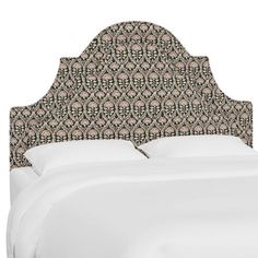 an upholstered headboard on a bed with white sheets