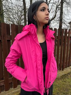 "Nice and bright functional clothing, a windbreaker nylon jacked in bright pink color.  2 slant side pockets with zip closing. Cotton jersey collar, arm ends I checked zips, all working well and are both functional and decorative elements.  Outside is nylon, inside fully lined with soft fleece material.  Brand - Superdry I suppose this item is from early 2000s,  but I do not know for sure year.  Good vintage condition, only small issue is light fiding roud hood's outer rim, but noticable just if looking carefully.  Size on the tag  S size   Please check measurements to insure a proper fit! Measurements:  48 cm  / \" armpit to armpit laying flat 56 cm/\"\"  total length  down or the edge" Sporty Pink Outerwear With Detachable Hood, Pink Waterproof Raincoat For Fall, Pink Nylon Hooded Jacket With Long Sleeves, Pink Long Sleeve Nylon Hooded Jacket, Pink Waterproof Long Sleeve Outerwear, Pink Waterproof Long Sleeve Raincoat, Pink Nylon Hooded Jacket For Winter, Pink Hooded Parka With Detachable Hood, Pink Waterproof Raincoat For Spring