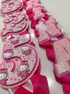 pink hello kitty birthday party decorations with number one and two on the top, along with ribbons