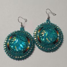 Hand-made beaded earrings: Colors: Teal w/fire colors  Closure: Hook size: 2 inches Festive Turquoise Beaded Earrings, Turquoise Beaded Round Earrings, Unique Turquoise Beaded Earrings, Unique Beaded Earrings With Bead Caps For Gift, Beaded Round Earrings For Festival, Artisan Bead Cap Earrings, Unique Beaded Earrings With Bead Caps, Festive Beaded Round Earrings, Festive Handmade Blue Beaded Earrings