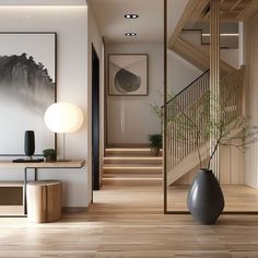 a large vase sitting on top of a wooden floor next to a stair case in front of a painting