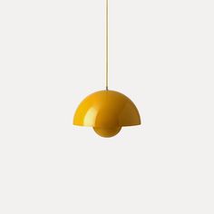 a yellow pendant light hanging from a ceiling