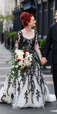 a bride and groom walking down the street holding hands