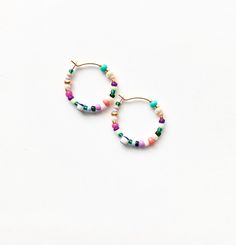 Small and colorful, beaded hoop earrings. Light weight with a bright, summer-y mix of colors. Made with a high quality mix of gorgeous seed beads. ✨Each piece is handmade to order and one-of-a-kind with variations in bead order.✨ Gold plated, 3/4 inch hoops. Looking for larges sizes? Medium Beaded Hoops: https://etsy.me/3xXuyrh Large Beaded Hoops: https://etsy.me/3nUPnzf 🌎 Packaging 🌎 To be environmentally responsible about packaging we will package orders together in the same box. If certain Package Orders, Seed Bead Hoop Earrings, Bead Hoop Earrings, Earring Inspo, Diy Bijoux, Gemstone Hoop Earrings, Tiny Hoop Earrings, Project Board, Handmade Earrings Beaded