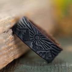 a ring that is sitting on top of a piece of wood with an intricate design