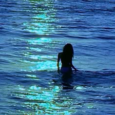 a woman is swimming in the ocean at night