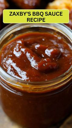 a jar filled with bbq sauce sitting on top of a wooden table