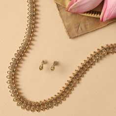 Description : This simple yet classic long necklace set is perfect for your next special event. The delicate floral design with Kempu stones will give you a classic yet modern look. Details & Specifications: Materials used: Brass Alloy with Antique Plating Weight – Necklace 17.14 gm, Earrings 2.73gm Length – Necklace 25 cm, Earrings 1.5 cm Make it custom Want to make it a custom long necklace? Sure! Reach out to us at support@tarinika.com and we’ll be happy to make possible modifications at no e Elegant Long Gold-tone Necklace, Gold Long Beaded Necklace Temple Jewelry, Antique Gold Brass Long Necklace, Classic Gold-tone Long Necklace, Elegant Gold-tone Metal Long Necklace, Antique Long Necklace, Long Necklace Set, Buy Jewellery Online, Indian Jewellery Design