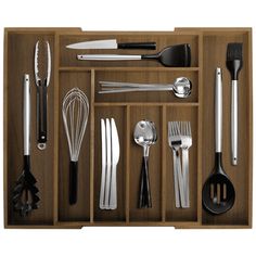 an assortment of kitchen utensils in a wooden drawer with spoons and spatulas