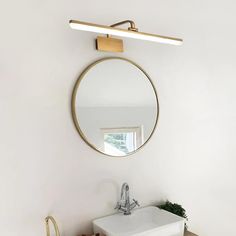 a white sink sitting under a mirror in a bathroom next to a wooden counter top