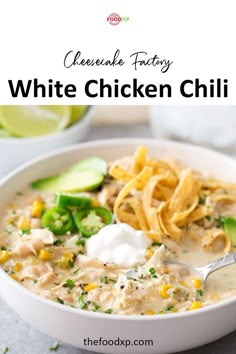 a white bowl filled with chicken chili next to tortilla chips and avocado