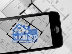 a cell phone with a drawing of a house on it and blueprints in the background