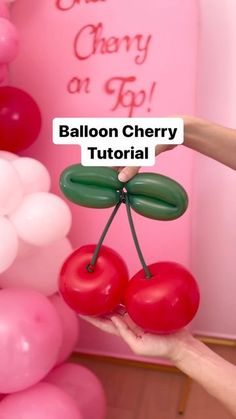 balloon cherry decoration being held in front of balloons