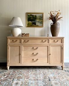 a large wooden dresser sitting on top of a carpeted floor next to a lamp