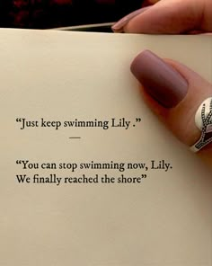 a woman's hand holding an open book with the words just keep swimming lily, you can stop swimming now, lily, we finally reached the shore