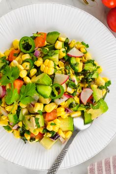 a white plate topped with corn and vegetables