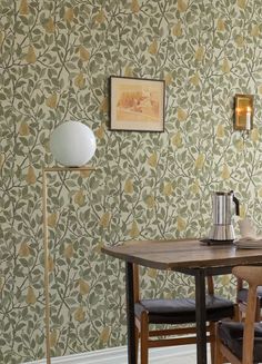 a wooden table sitting under a lamp next to a wall