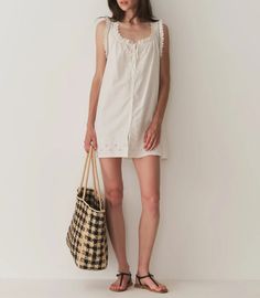 Crafted from 100% organic cotton poplin, the Nessie Dress—inspired by our bestselling Traveler Top—is a sleeveless style with a breezy cut, mother-of-pearl buttons, and a scoop neckline with a grosgrain ribbon tie. The neckline and sleeve openings are adorned with scallop eyelet detailing and ladder trim, while the yoke and mini hemline feature a floral eyelet design. Scalloped Trim, Summer 24, Naturally Dyed, Ribbon Tie, Mother Of Pearl Buttons, Pearl Buttons, Grosgrain Ribbon, Cotton Poplin, Scoop Neckline