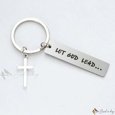 a metal keychain with a cross on it that says let god lead,