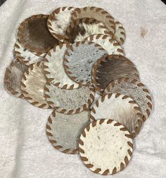 a pile of rugs on top of a white sheet covered in brown and beige colors