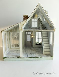 the doll house is made out of wood and has stairs leading up to the second floor