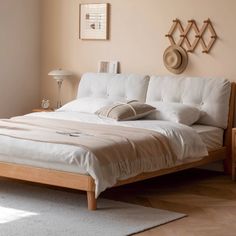 a white bed sitting in a bedroom next to a wooden dresser and lamp on top of a hard wood floor