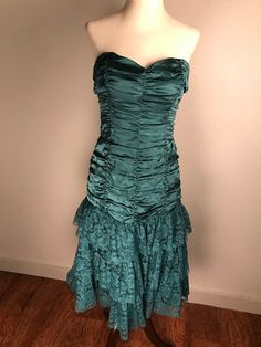 This amazing teal colored vintage silk Betsey Johnson Evening gown is like a glass of fine champagne in candle light. It's beautifully ruched bodice of satiny silk flows down low over the hips where it meets three gathered layers of matching  Floral lacy tulle. It has a back zipper and the bodice is lightly boned. The skirt has three layers of lining. Gorgeous dress! It is in very good preowned condition. It is a size 10 but keep in mind that Betsey's clothes tend to run small. Measurements are Green Ruched Evening Dress For Formal Occasions, Green Ruched Evening Dress For Wedding, Silk Ruched Evening Dress With Sweetheart Neckline, Green Silk Evening Dress With Ruched Bodice, Green Silk Evening Dress With Pleated Bodice, Vintage Ruched Dress With Fitted Bodice, Vintage Silk Evening Dress With Fitted Bodice, Green Silk Evening Dress For Prom Season, Green Silk Evening Dress For Prom