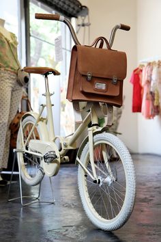 a white bicycle with a brown bag on the back