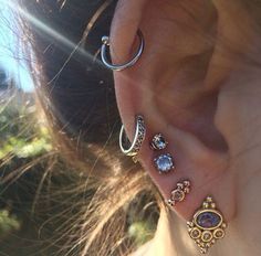 a close up of a person's ear with different types of piercings on it