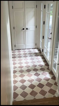 a hallway with two doors and a checkered floor