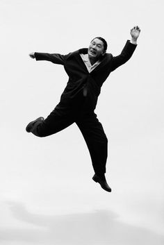 a man in a suit jumps into the air