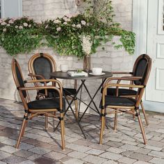 two chairs and a table outside with flowers