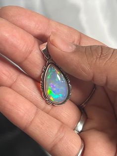 Embrace your best self with these magical Ethiopian Opal pendants. The brilliant southwest-styled setting and glowing teardrop stone make this exquisite pendant an excellent statement piece. Opals have been revered by many cultures for their unique mystical beauty and the belief that they protect against negative energy and soothe sadness. This lustrous pendant adds a touch of splendor to any outfit with its fiery hues. You won't be disappointed. Materials: .925 Sterling Silver, Ethiopian Opal A Multicolor Teardrop Spiritual Jewelry, Handmade Teardrop Opal Jewelry, Opal Teardrop Jewelry With Natural Stones, Unique Teardrop Stone-set Jewelry, Unique Teardrop Stone Setting Jewelry, Unique Teardrop Shaped Jewelry With Stone Setting, Mystical Teardrop Gemstone Jewelry, Mystical Teardrop Sterling Silver Jewelry, Spiritual Teardrop Cabochon Necklace