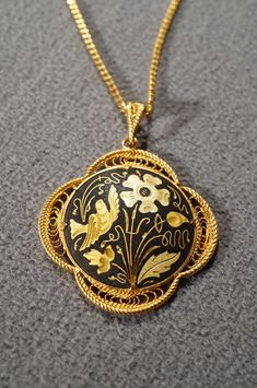 I am offering this fabulous vintage yellow gold tone necklace. This piece is truly gorgeous, and it has the following features: * beautiful vintage necklace * yellow gold tone * jet black enameled * flower design * pendant measuring 1.5 inches in diameter * 19 inches in length This is a fantastic and classic piece. There is tons of sparkle and shine with this piece. It will beautifully complement your upcoming fashion season. Buyer pays all shipping and handling. Formal Enamel Medallion Necklace, Victorian Enamel Yellow Gold Necklace, Vintage Black Enamel Necklace For Formal Occasions, Victorian Yellow Gold Enamel Necklace, Vintage Black Enamel Necklaces For Formal Occasions, Victorian Style Yellow Gold Enamel Necklace, Gold Enamel Medallion Necklace, Antique Yellow Gold Enamel Necklace, Vintage Black Enamel Necklace For Evening