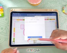 two hands are pointing at an ipad screen with sticky notes on it and candy in the background