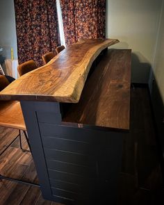 a wooden counter top sitting on top of a hard wood floor next to a window