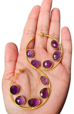 Beautiful, hand crafted statement hoops with faceted amethyst gemstones in a regal purple hue. 14k gold plated nickel free brass genuine amethyst gemstones dimension: approx. 1.75" handcrafted by artisans Luxury Oval Gemstone Hoop Earrings, Amethyst Gold, Purple Hues, Amethyst Gemstone, Gold Hoop, Gold Hoop Earrings, Stone Earrings, Beautiful Hand, Hand Crafted