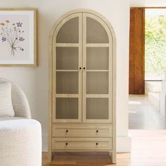 a white armoire sitting next to a couch in a living room