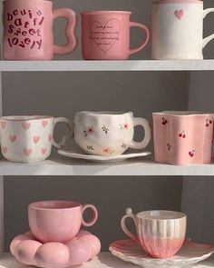 pink and white coffee cups on shelves with hearts painted on the mugs, saucers and plates