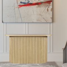 a painting hanging on the wall above a radiator in a room with white walls