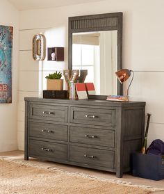 a dresser with a large mirror on top of it