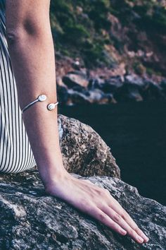 Our 925 Sterling silver delicate bracelet is perfect for elegant ocasions. This unique design consists in two stones of Santa Lucia 14 mm in oval shape, a natural shell also know as Shiva Eye Shell. The shiva shell is a natural fossil seashell. This piece is fully adjustable, able to wear it on the up side of the arm or on the wirst. This delicate bracelet is the a perfect present for all those who loves the sea and natural beauty. Details: - 925 Sterling Silver Stamp - Able for sensitive skins. Sterling Silver Jubilee Bracelet For Friendship, Minimalist White Sterling Silver Bangle Bracelet, Minimalist White Sterling Silver Bangle, Adjustable Silver Pearl Bracelet For Friendship, Adjustable Minimalist Sterling Silver Bracelet, Silver Minimalist Name Bracelet, Adjustable White Gold Sterling Silver Oyster Bracelet, Adjustable Sterling Silver Bracelet In White Gold, White Sterling Silver Friendship Bracelets