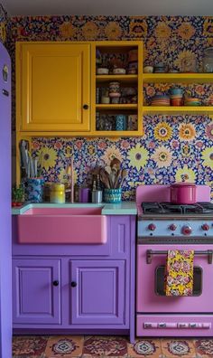 a colorful kitchen with yellow cabinets and purple stove